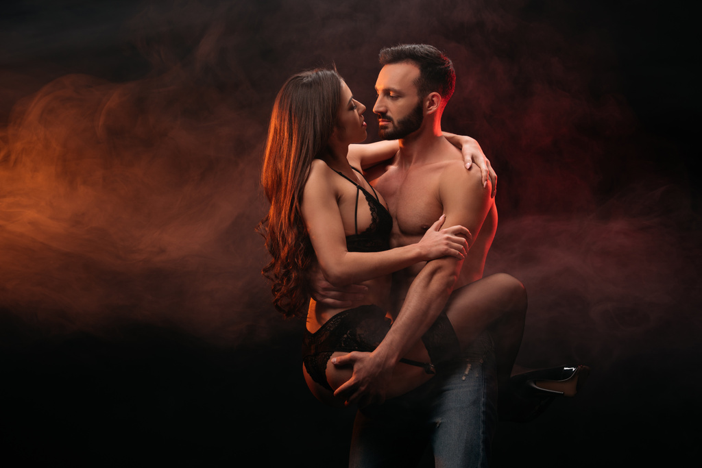 пристрасна пара обіймається в димній кімнаті
 - Фото, зображення