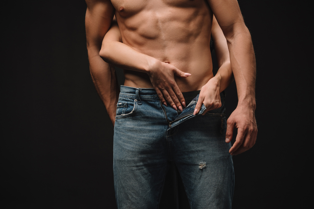 περικοπεί προβολή παθιασμένη Γυναίκα Γδύνοντας shirtless άνδρα σε απομονωμένα σε μαύρο τζιν - Φωτογραφία, εικόνα