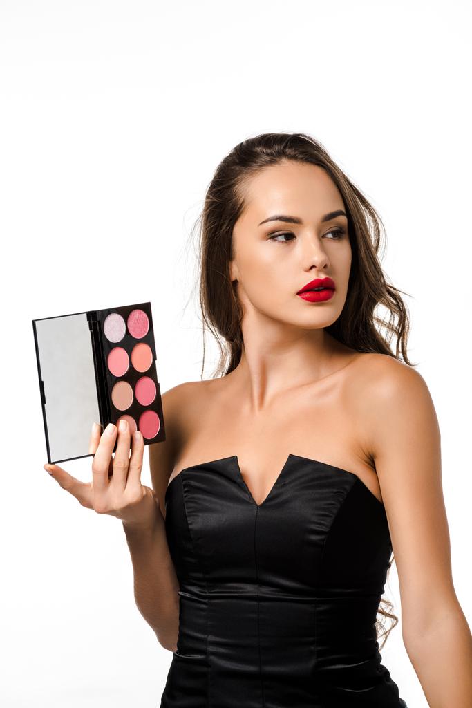 attractive girl in black dress with red lips holding palette with eyeshadows isolated on white - Photo, Image