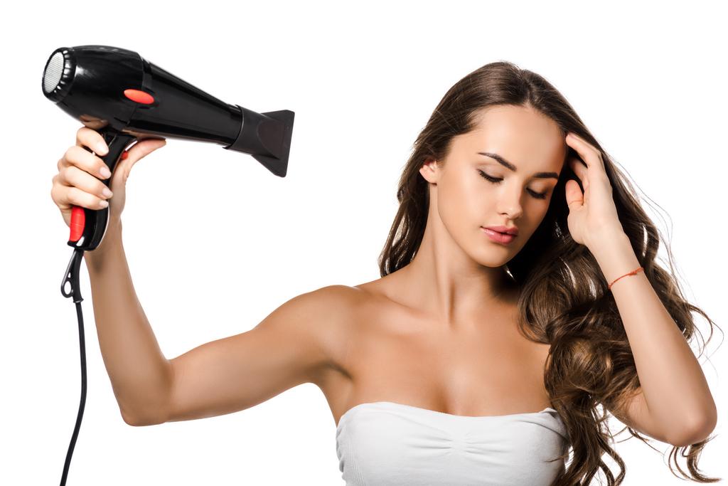 saç kurutma makinesi üzerinde beyaz izole kullanan güzel kız - Fotoğraf, Görsel