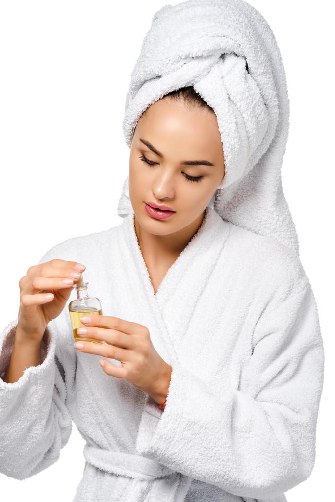 attractive girl in bathrobe holding bottle of oil isolated on white - Photo, Image