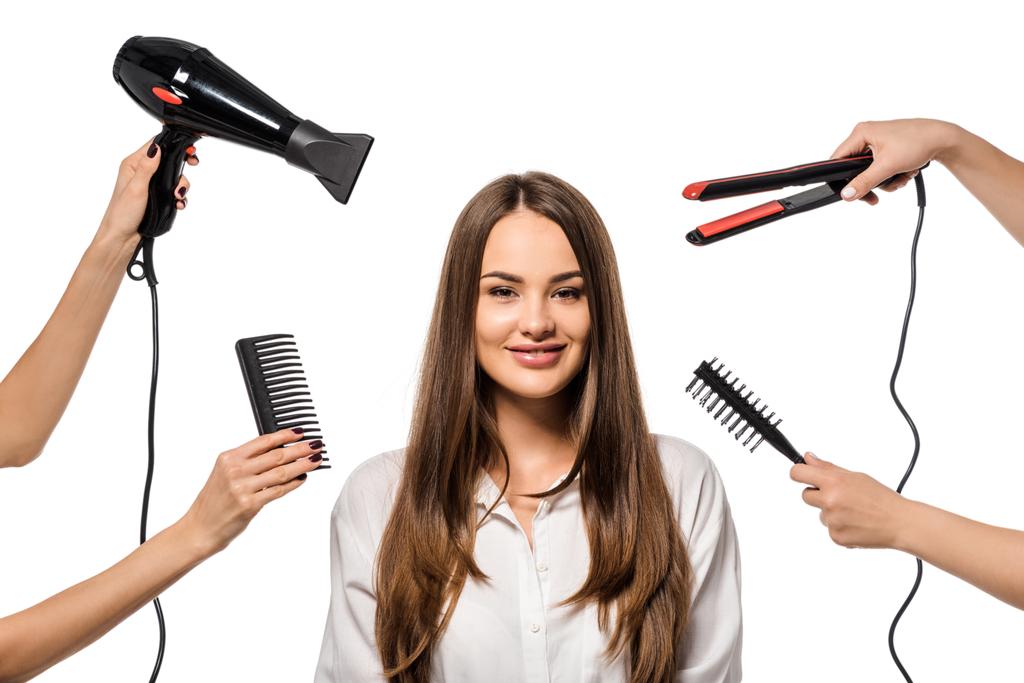 Женщины держат аксессуары парикмахера вокруг красивой девушки, смотрящей в камеру
 - Фото, изображение