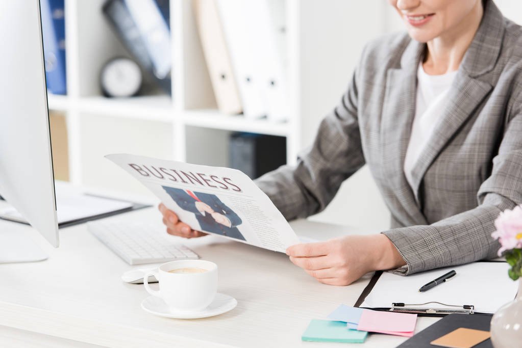 immagine ritagliata della donna d'affari che legge il giornale in ufficio
 - Foto, immagini
