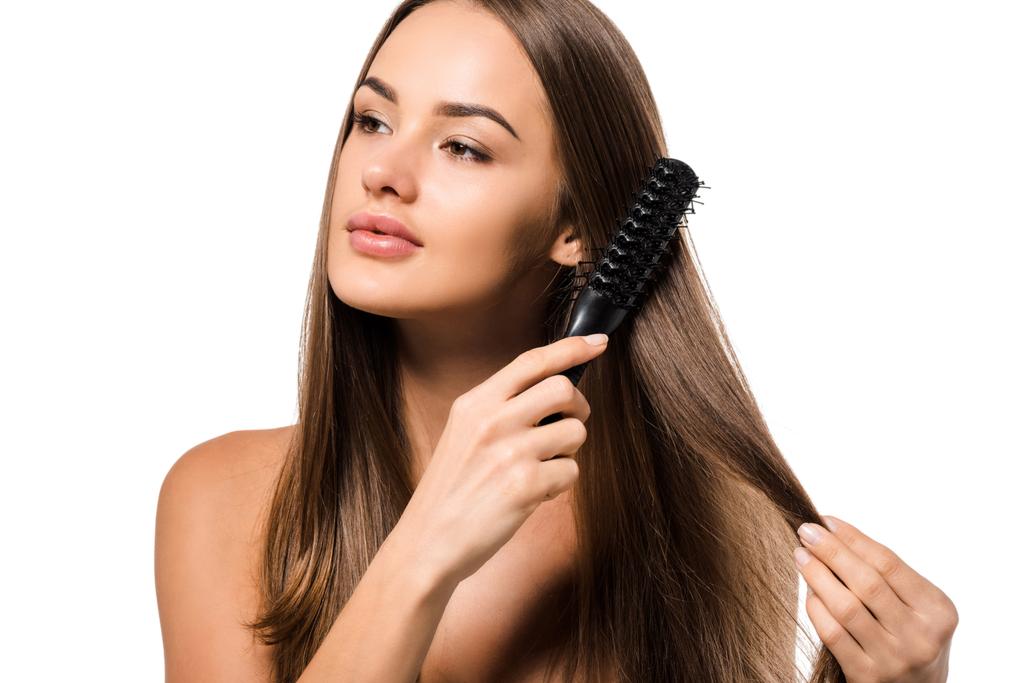 привлекательная девушка расчесывает длинные каштановые волосы с расчёской, изолированной на белом
 - Фото, изображение