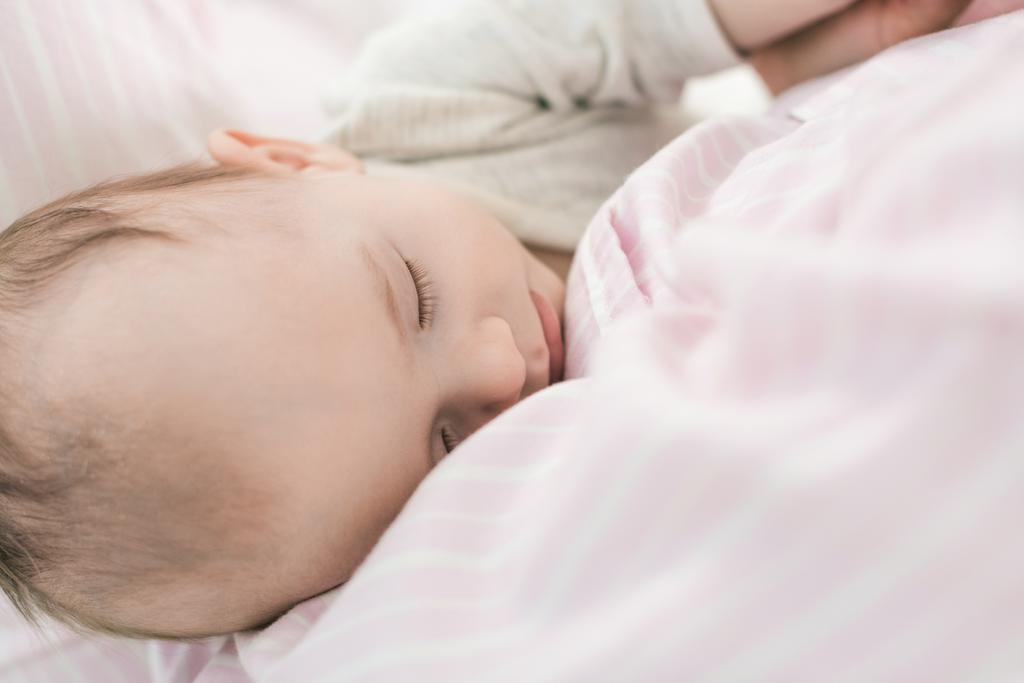 Μερική άποψη του χαριτωμένο μωρό που κοιμάται σε μητέρες χέρια - Φωτογραφία, εικόνα