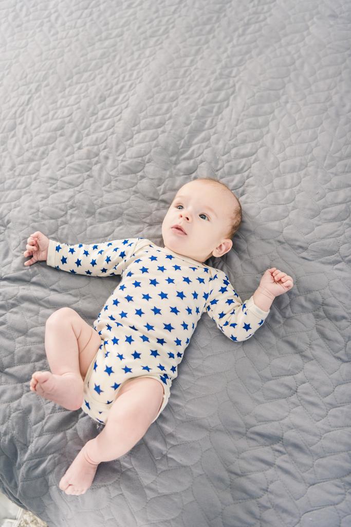 vista de cerca del adorable bebé acostado sobre una manta gris
 - Foto, Imagen