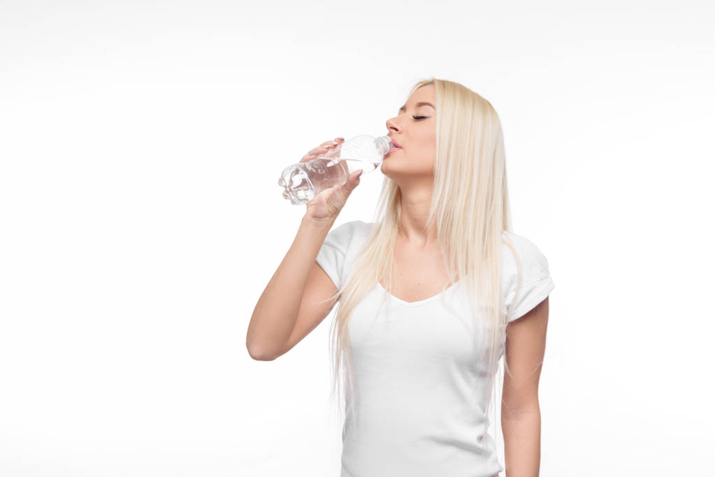 Zdravá blondýnka hospodářství a pít sklenici čisté vody na izolované bílém pozadí - Fotografie, Obrázek
