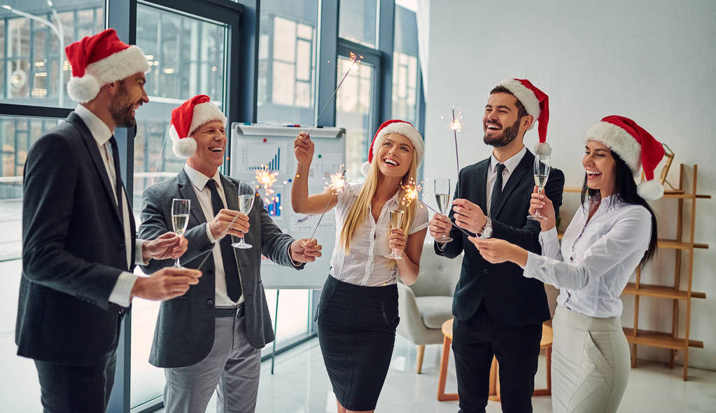 Feliz Navidad y Feliz Año Nuevo! Grupo de trabajadores de oficina que celebran las vacaciones de invierno juntos en el trabajo. Gente de negocios bebiendo champán en la oficina
. - Foto, imagen