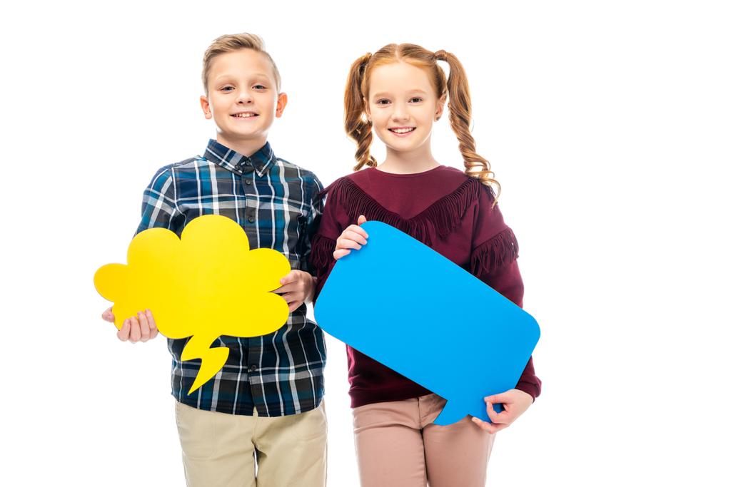 smiling kids standing, holding multicolored speech bubbles and looking at camera isolated on white - Photo, Image