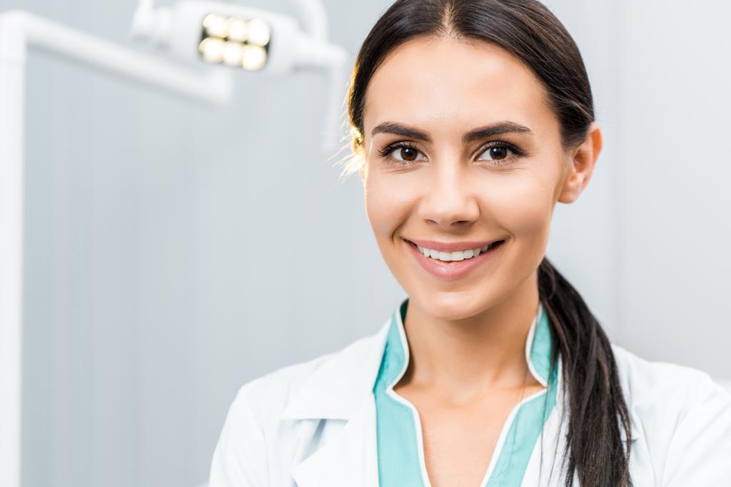 zblízka usmívající se žena zubního lékaře v zubní klinice - Fotografie, Obrázek