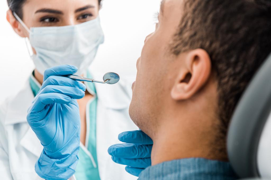 foco seletivo das mãos femininas do dentista em luvas de látex examinando paciente afro-americano
  - Foto, Imagem
