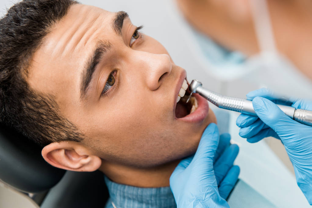 アフリカ系アメリカ人の患者さんの歯を削る歯医者手のクローズ アップ - 写真・画像