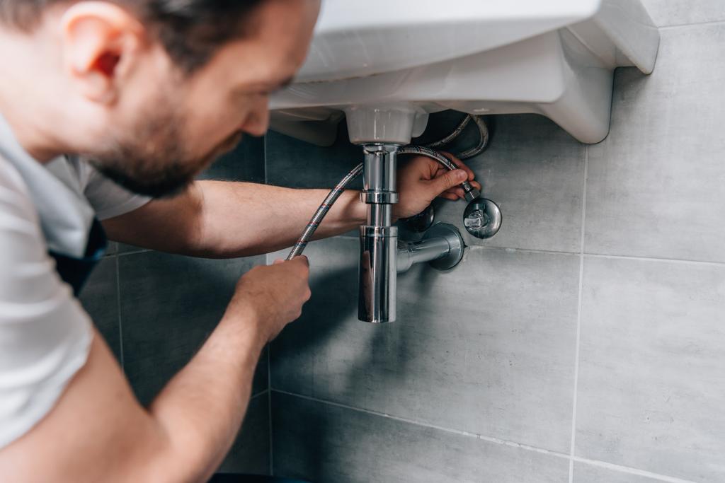 foyer sélectif du plombier masculin dans le travail évier de fixation globale dans la salle de bain
  - Photo, image