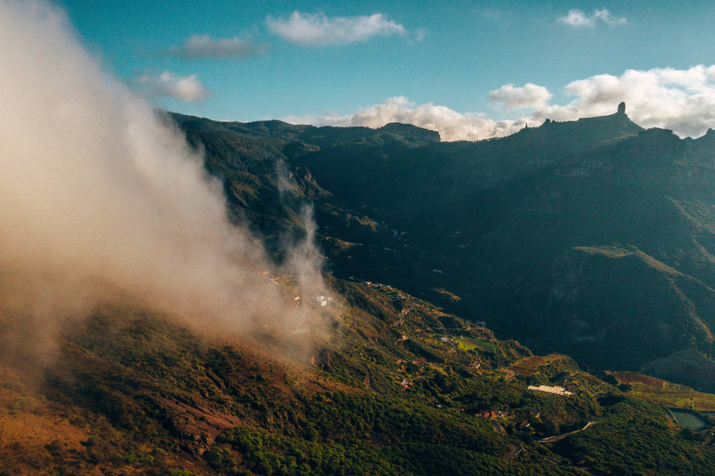 Luchtfoto van de bergen van Gran Canaria in het midden van het eiland met uitzicht op de Teide vulkaan boven de wolken. - Foto, afbeelding