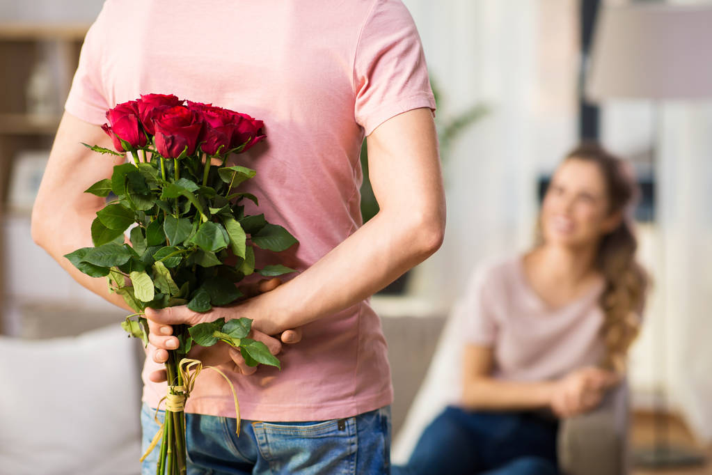 mujer y hombre con racimo de rosas a sus espaldas
 - Foto, Imagen