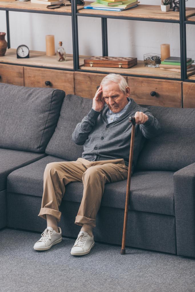 gri saçlı kanepede otururken baş ağrısı olan emekli adam  - Fotoğraf, Görsel