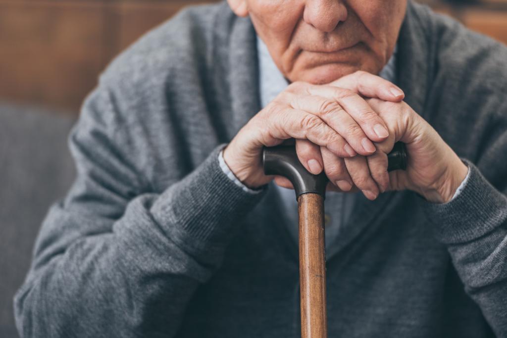 обрезанный вид расстроенного пенсионера с тростью
 - Фото, изображение