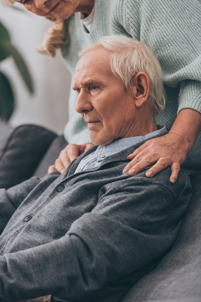 Ausgeschnittener Blick auf Rentnerin umarmt Ehemann zu Hause  - Foto, Bild