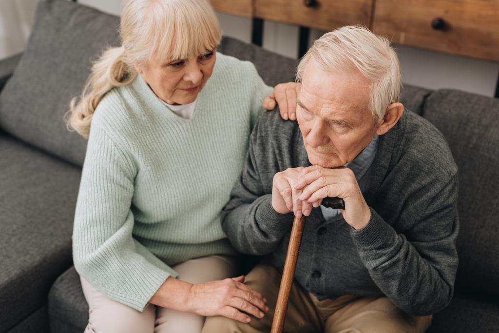 sostegno moglie anziana seduta vicino triste marito in pensione con bastone da passeggio
  - Foto, immagini