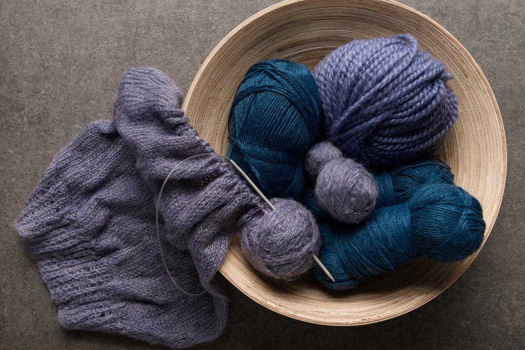 flat lay with purple and blue yarn balls in bowl on grey background - Photo, Image