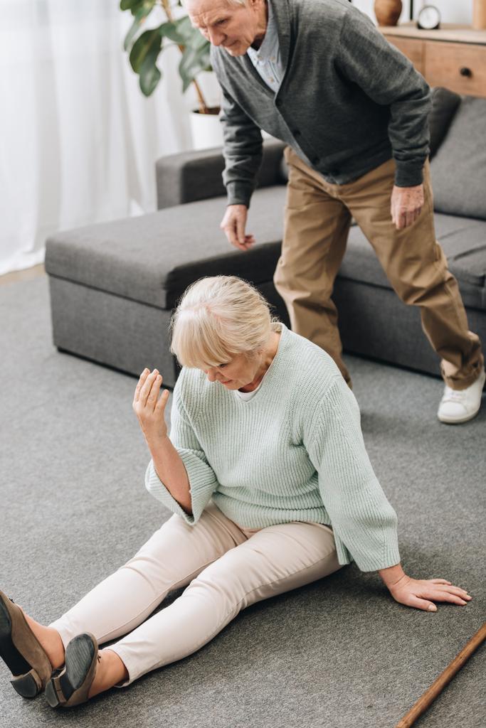 Rentnerehepaar bedrängt Ehefrau auf dem Boden sitzend  - Foto, Bild