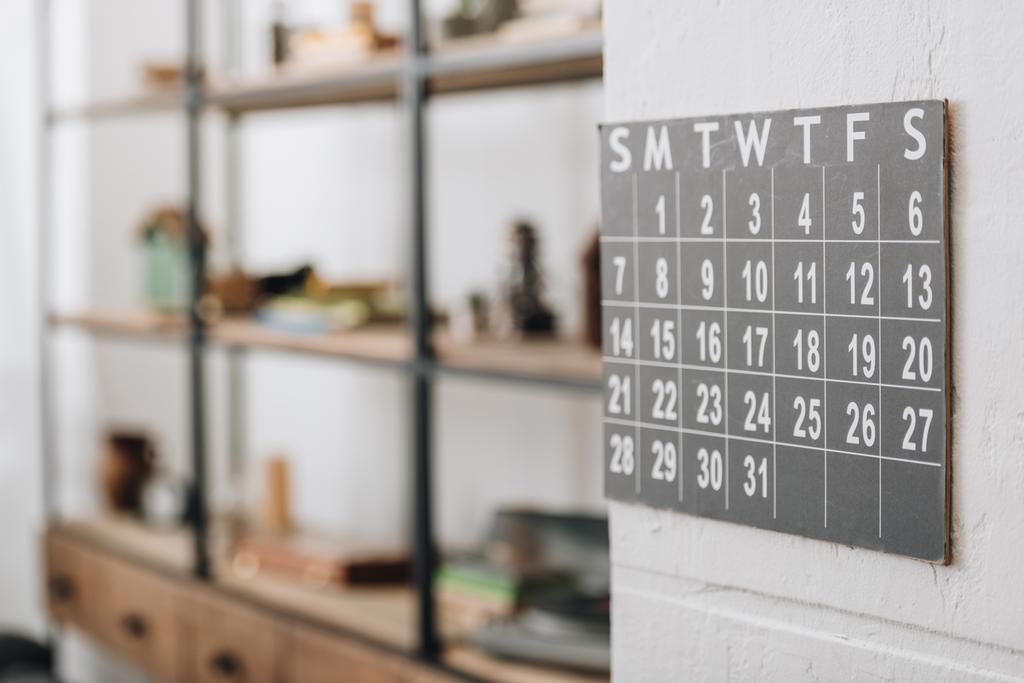 enfoque selectivo del calendario de pared que muestra las fechas en la sala de estar
 - Foto, Imagen