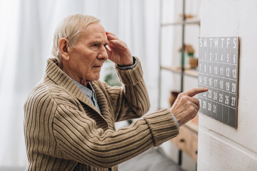 Παλιά ο άνθρωπος εξετάζοντας ημερολόγιο και επαφή με το κεφάλι - Φωτογραφία, εικόνα