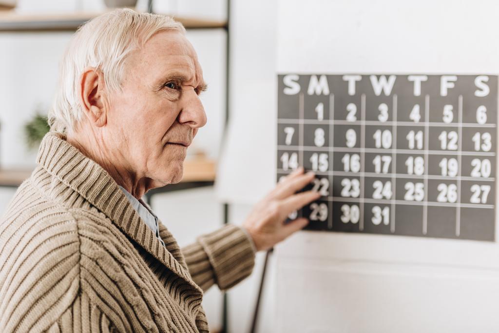 selektywne focus starszy człowiek, dotykając Kalendarz ścienny i pamięć do dat - Zdjęcie, obraz