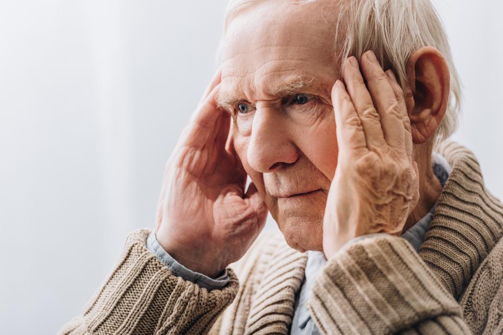 Close up van gepensioneerde man met hoofdpijn  - Foto, afbeelding