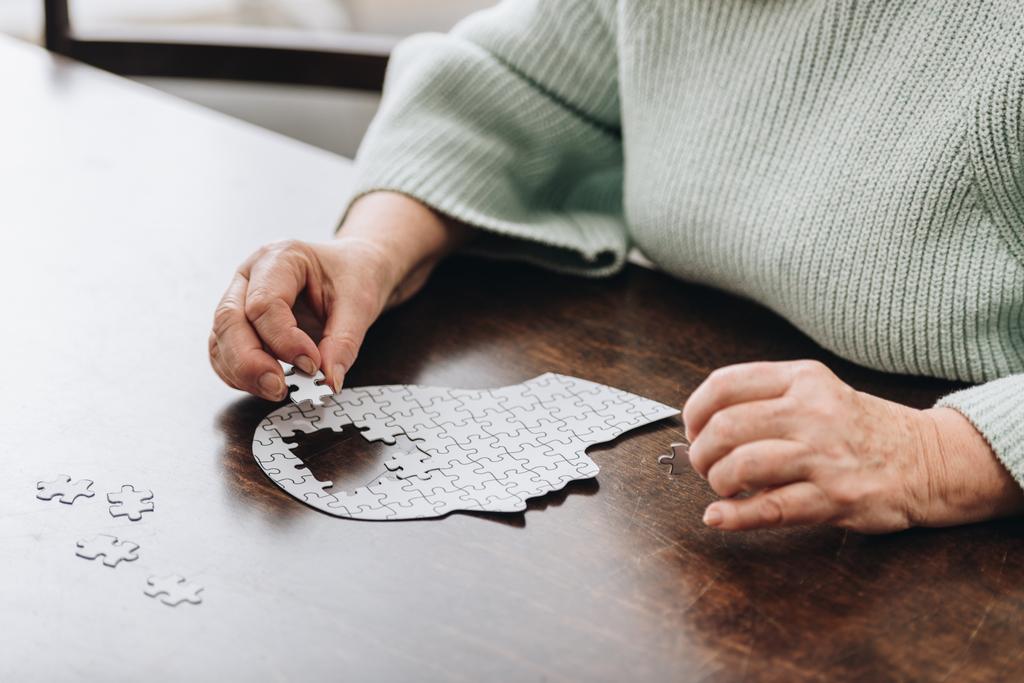 обрезанный вид пожилой женщины, играющей с головоломками
  - Фото, изображение