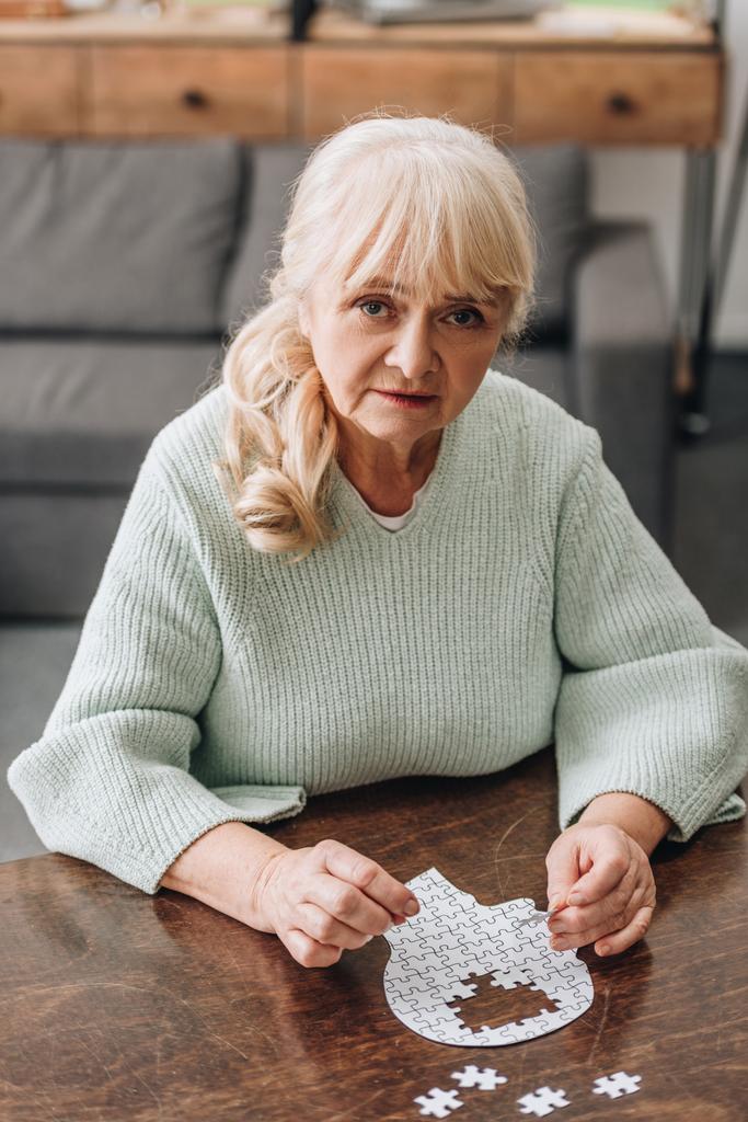mulher idosa loira brincando com quebra-cabeças em casa
  - Foto, Imagem