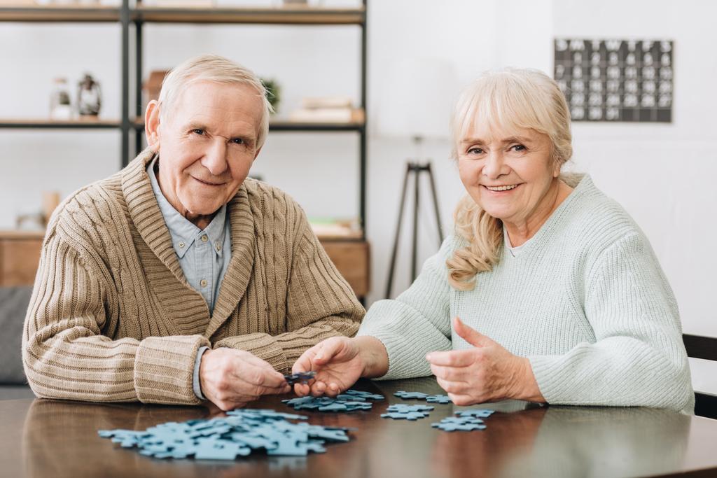 joyeux couple retraité jouant avec des puzzles à la maison
 - Photo, image