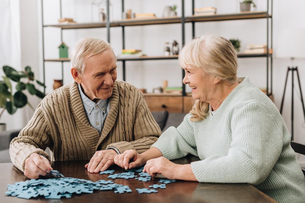 glückliches Seniorenpaar spielt zu Hause mit Rätseln - Foto, Bild