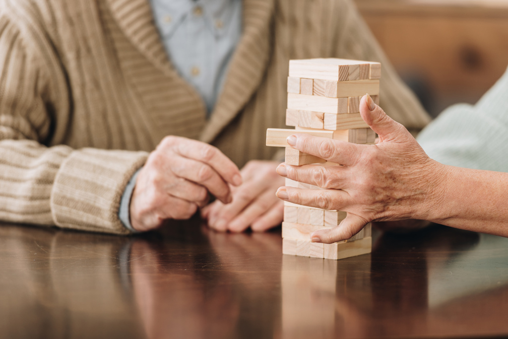 cropped view of senior couple playing jenga at home - Photo, Image