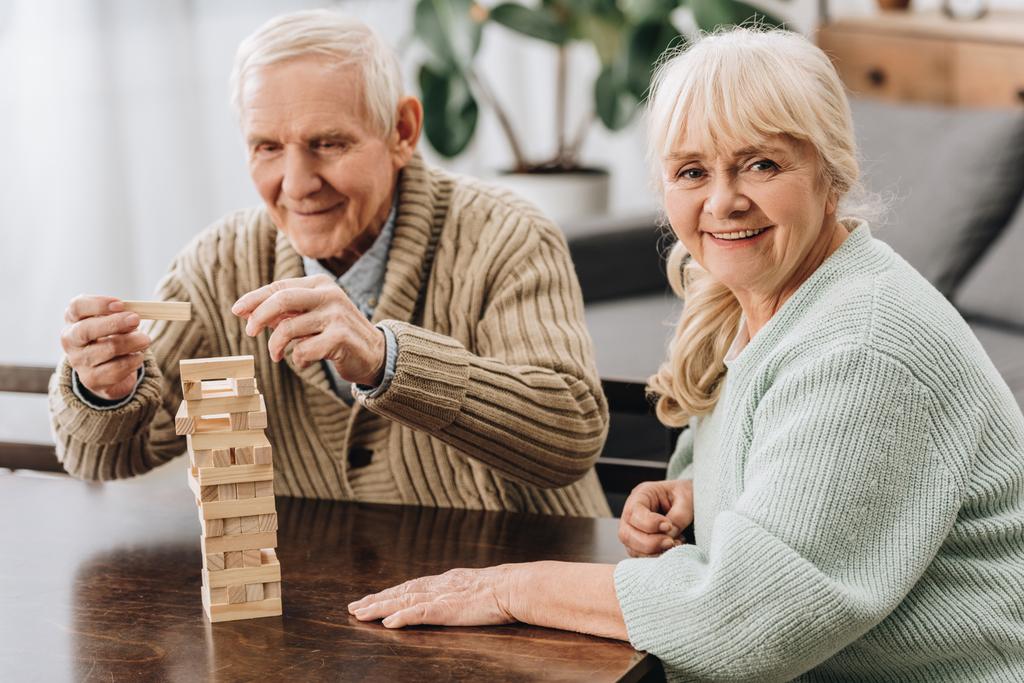 aposentados felizes jogando jenga jogo na mesa
 - Foto, Imagem