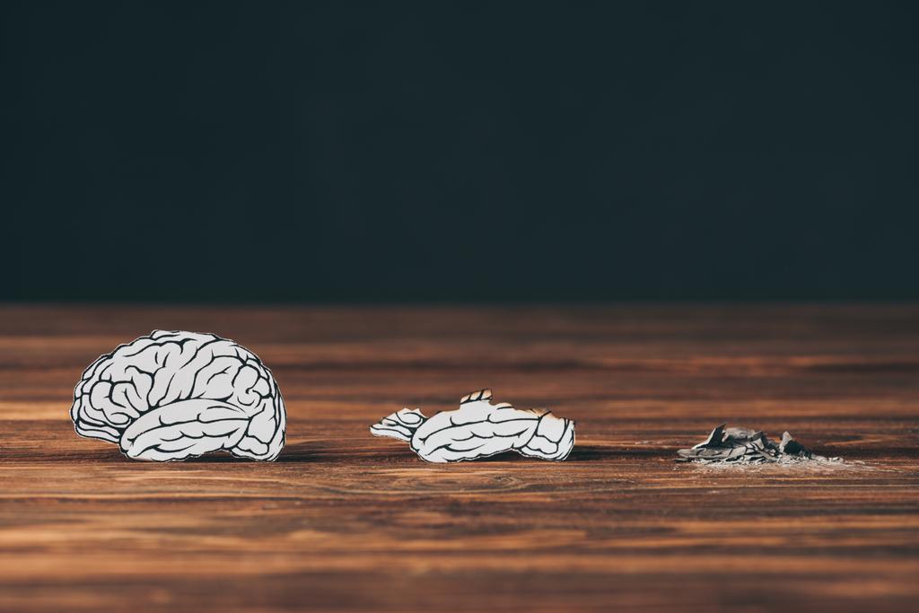 Papiere mit Gehirnerkrankung als Demenzsymbol auf schwarzem Hintergrund  - Foto, Bild