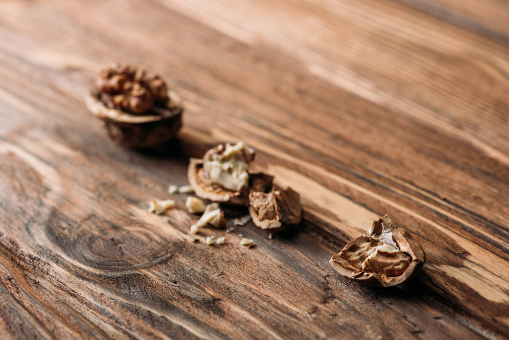 ραγισμένα καρύδια στα κελύφη ξηρών καρπών ως σύμβολο alzheimer στο ξύλινο τραπέζι  - Φωτογραφία, εικόνα
