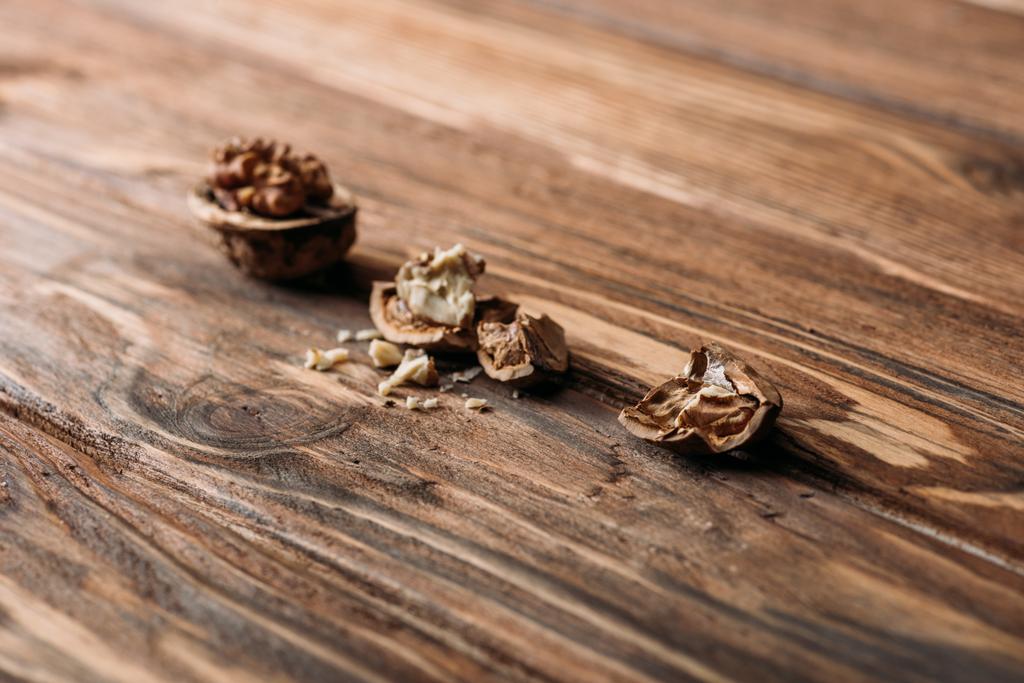 cracked walnuts in nut shells as dementia symbol on wooden table  - Photo, Image