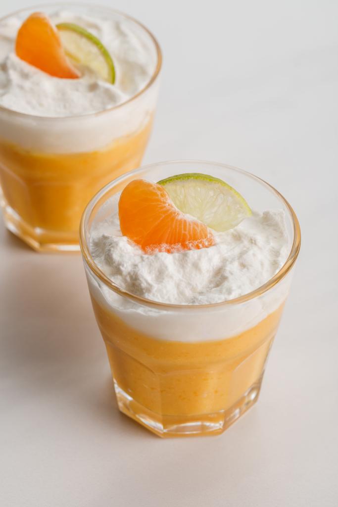 Orangensahnedesserts mit Mandarine und Limettenscheiben im Glas - Foto, Bild