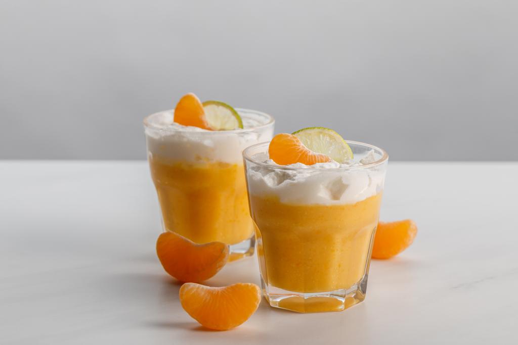 due bicchieri con dessert alla panna con fette di mandarino e lime
 - Foto, immagini