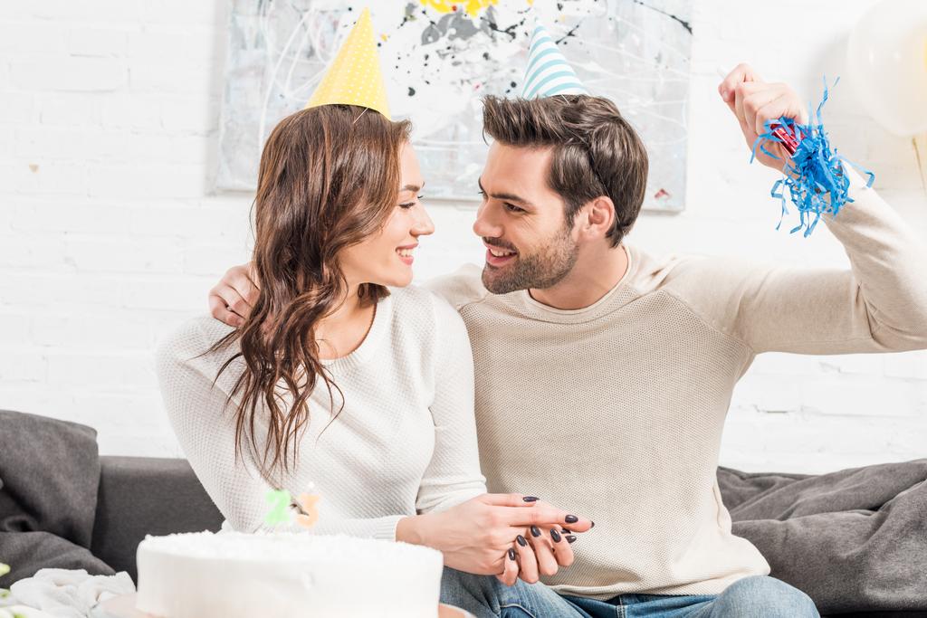 šťastný pár v klobouky slaví narozeniny s dort a strany roh doma - Fotografie, Obrázek