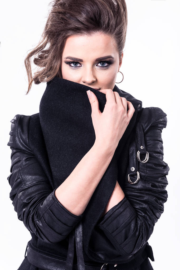 fiatal nő tervezett fekete kabát, bőr részletek és big divatos gallér, pózol a fehér háttér - Fotó, kép