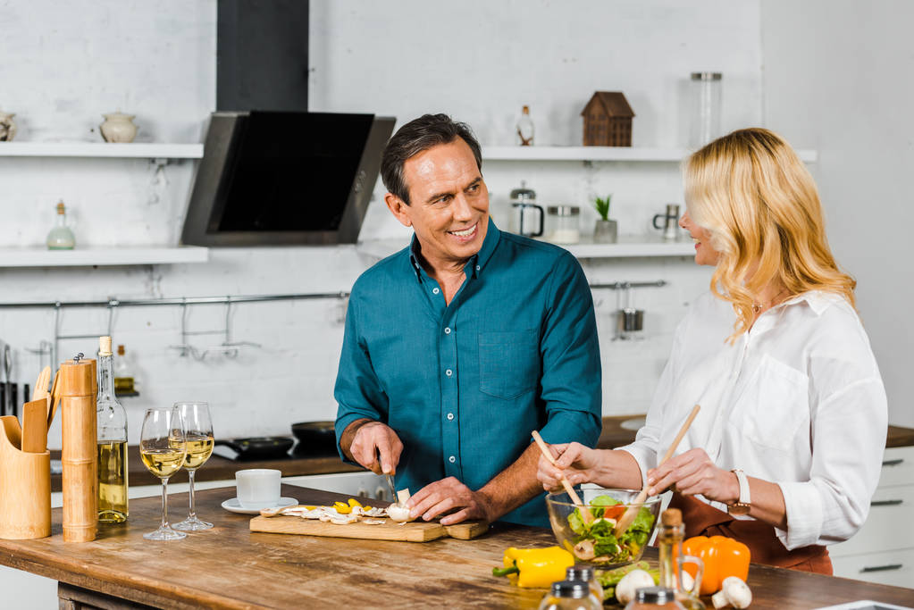 moglie matura e marito cucinare insalata insieme in cucina
 - Foto, immagini