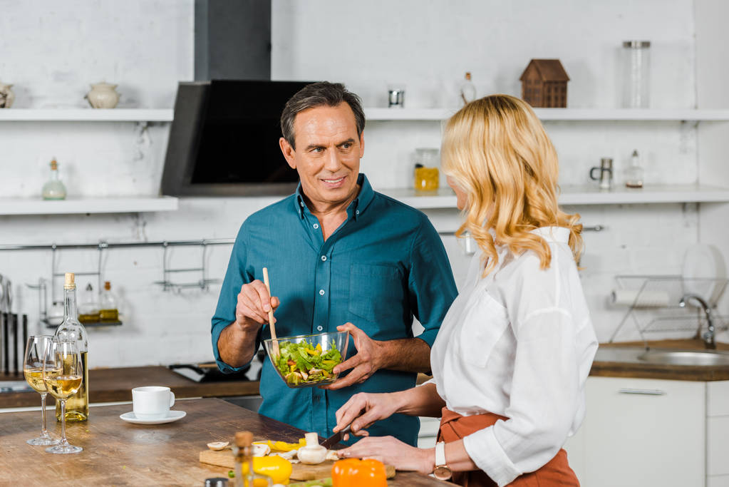 зріла дружина і чоловік готують салат разом на кухні
 - Фото, зображення