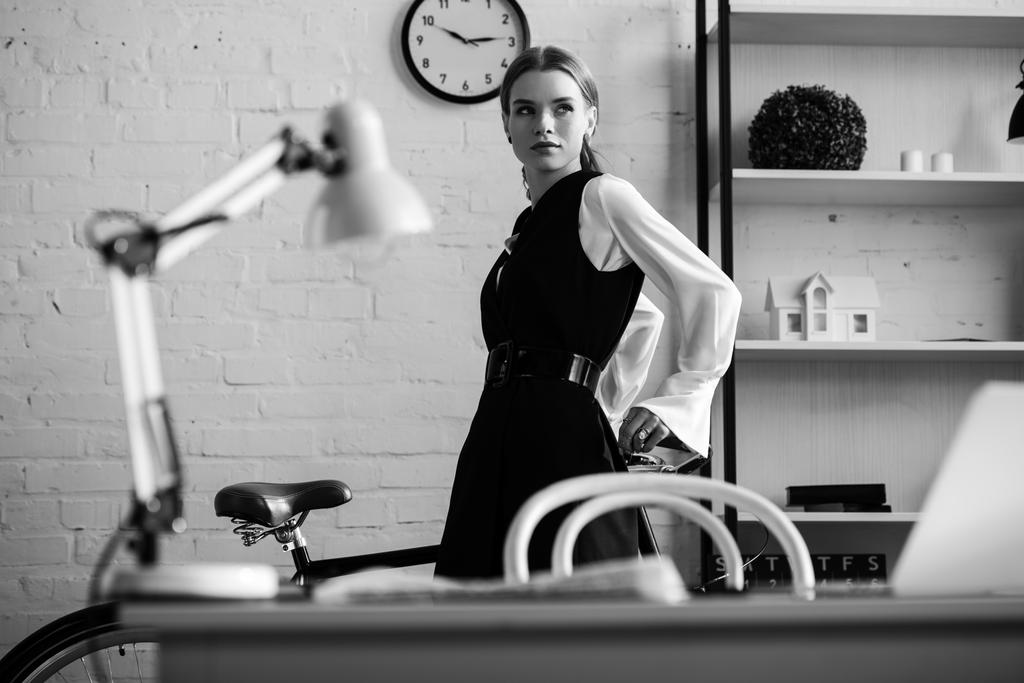 Schwarz-Weiß-Foto einer Geschäftsfrau in offizieller Kleidung am Arbeitsplatz - Foto, Bild