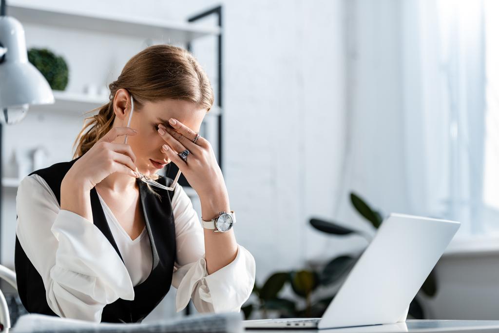 kobieta interesu w wizytowym siedząc przy biurku komputer, dotykając czołem i cierpiących na ból głowy w miejscu pracy - Zdjęcie, obraz