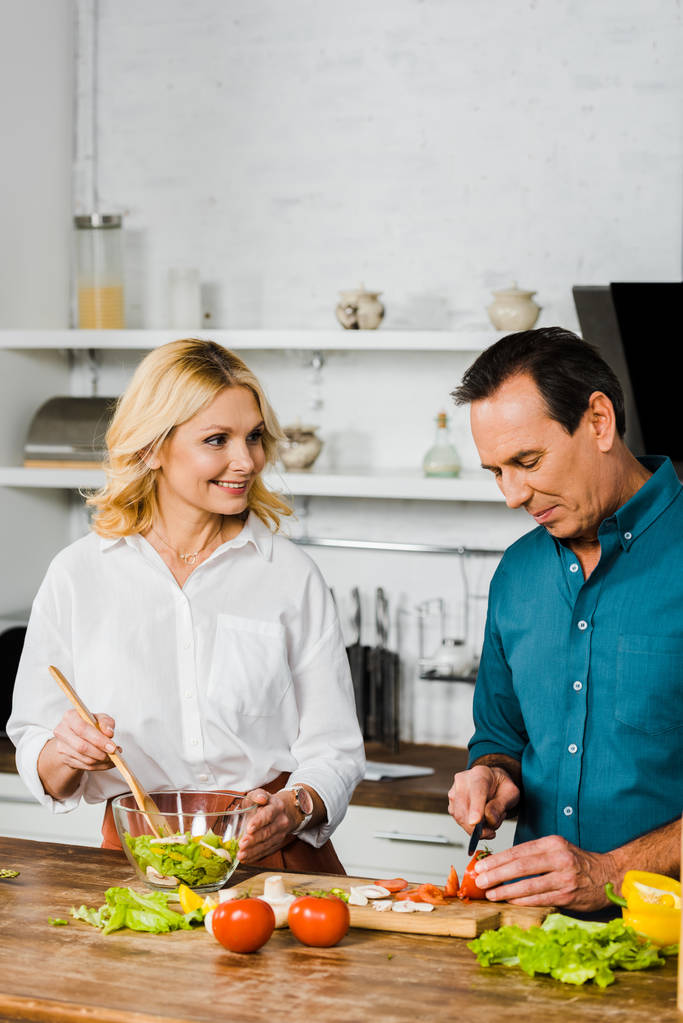 érett feleség és a férj főzés az egészséges saláta össze a konyha - Fotó, kép
