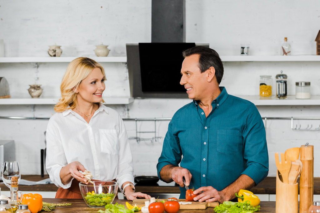 casal maduro cozinhar salada orgânica juntos na cozinha
 - Foto, Imagem
