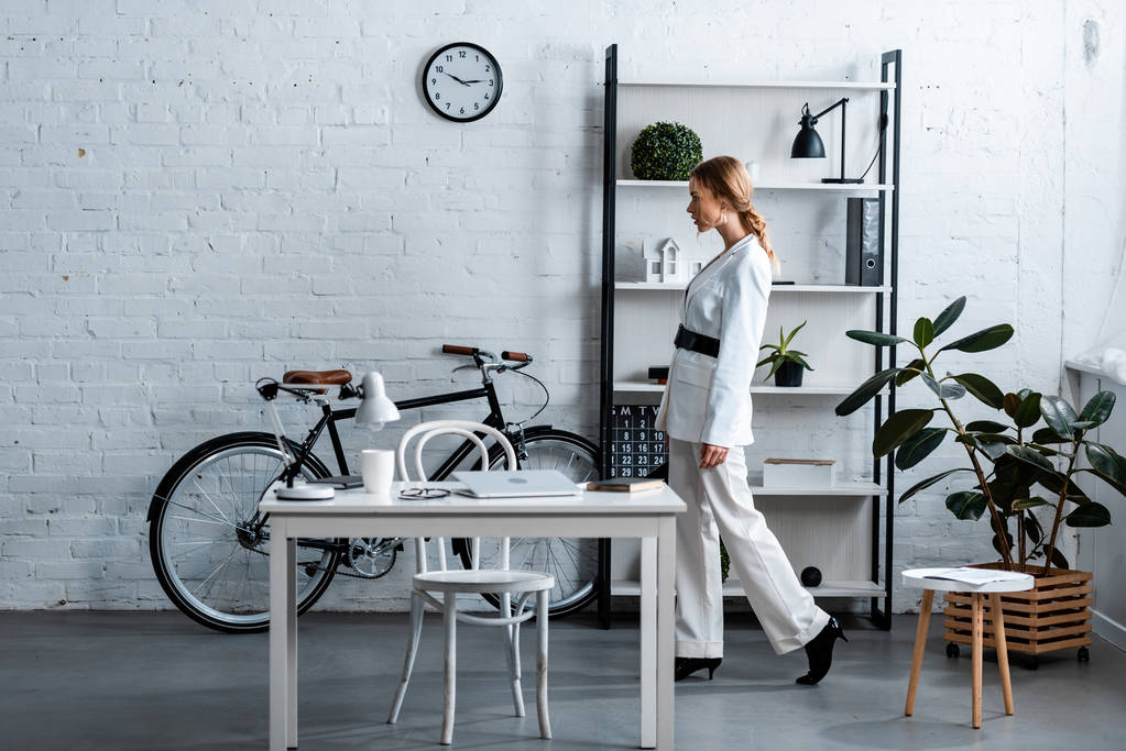 бізнес-леді в білому формальному одязі в сучасному офісному інтер'єрі
 - Фото, зображення