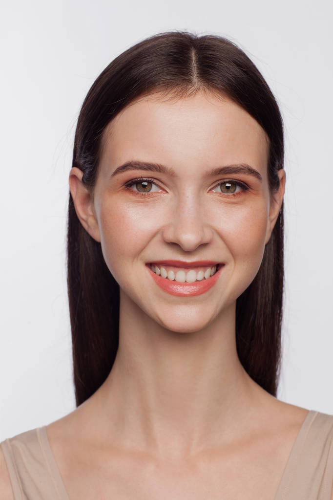 Portret van een lachende mooie jonge vrouw. Witte achtergrond - Foto, afbeelding
